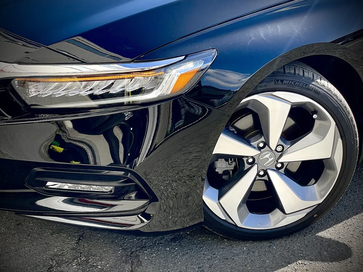Gloss black paint and polished wheel after an exterior detail