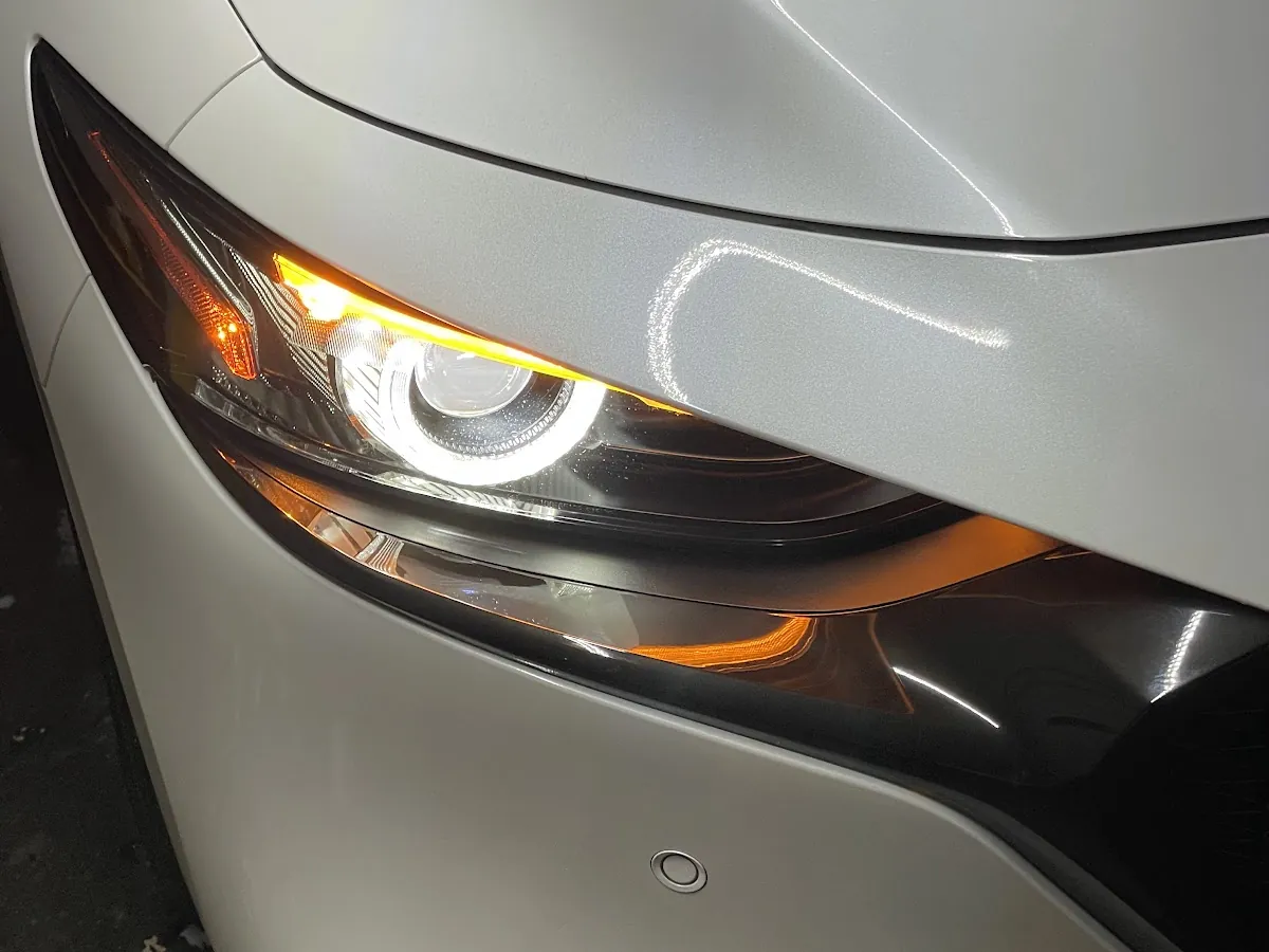 Crystal-clear restored headlight on a silver Mazda